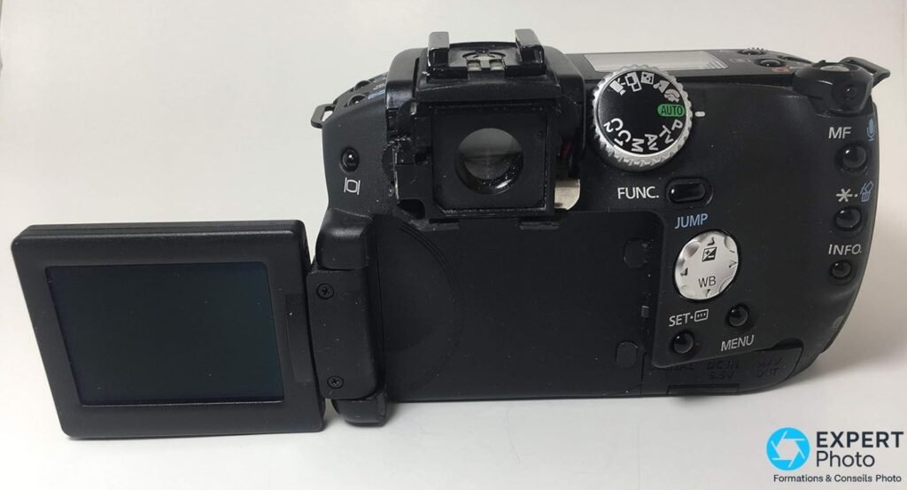 Canon PowerShot Pro1 vu de dos avec écran LCD orientable sorti latéralement à gauche, écran éteint, viseur visible.