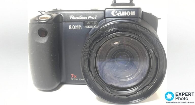 Canon PowerShot Pro1 vu de face, objectif zoom 7x déployé et marquages PowerShot Pro1 et Canon visibles sur le boîtier.