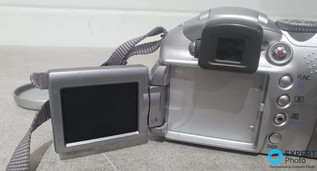 Canon PowerShot S2 IS avec écran LCD orientable 1,8 pouce déplié sur le côté gauche du boîtier, viseur électronique visible. 