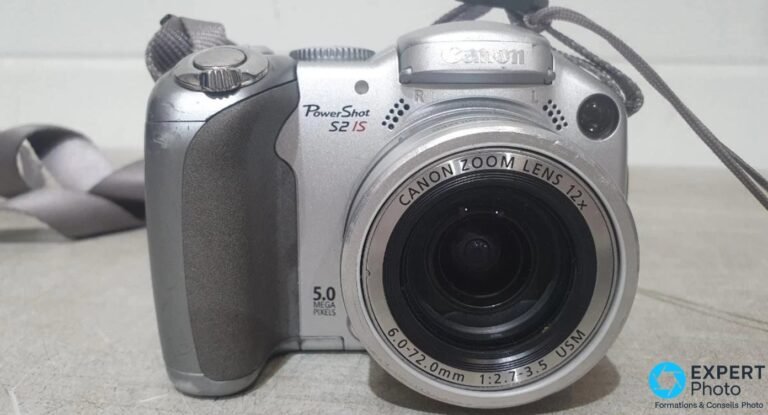 Canon PowerShot S2 IS argent vu de face en trois-quarts, objectif Canon Zoom Lens 12x et marquage 5.0 mégapixels visibles.