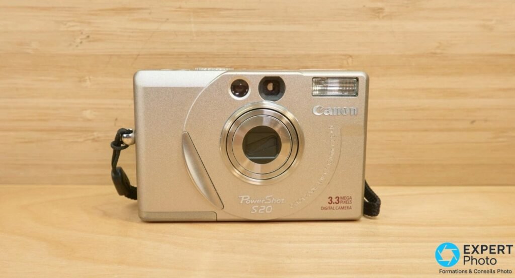 Canon PowerShot S20 vu de face, boîtier champagne, objectif rétracté, logo PowerShot S20 et 3,3 Mpx visibles.