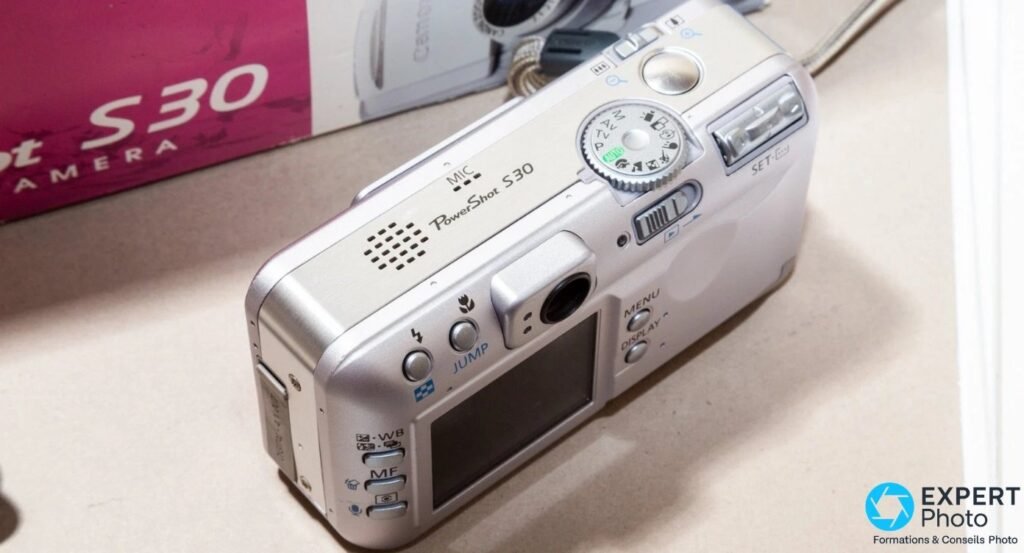 Canon PowerShot S30 vu du dessus, molette M, Av, Tv, P, Auto, déclencheur et marquage PowerShot S30 visibles. 