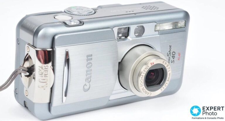 Canon PowerShot S40 trois-quarts avant, cache coulissant ouvert, objectif zoom 7.1-21.3mm sorti, étiquette 4 MP visible