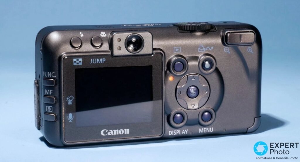 Canon PowerShot S70 vue arrière avec écran LCD, viseur optique, pavé directionnel, boutons FUNC, MF, DISPLAY et MENU.