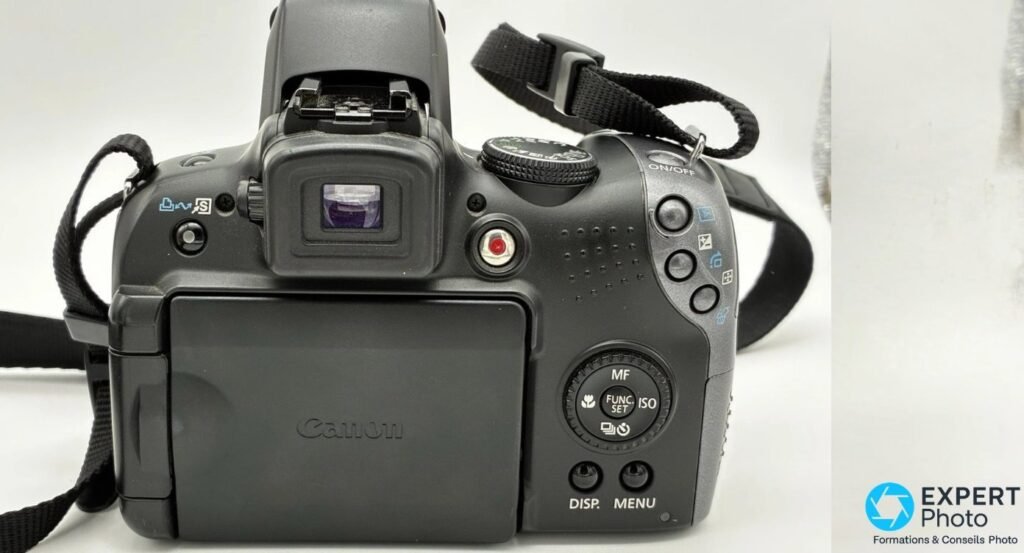 Canon PowerShot SX10 IS vue arrière, écran LCD orientable replié logo Canon, viseur électronique, molette MF FUNC SET ISO