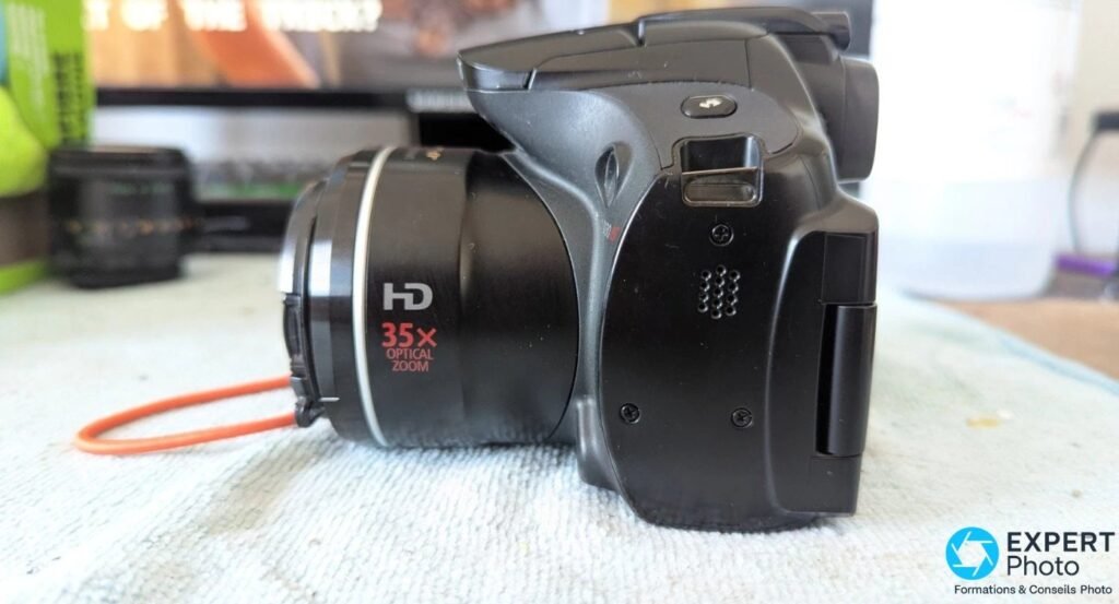 Profil gauche du Canon PowerShot SX30 IS, flash escamotable en position relevée et marquage 35× sur l'objectif.