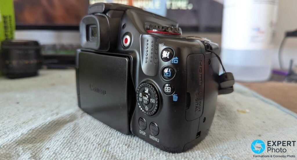 Vue arrière du Canon PowerShot SX30 IS, écran articulé replié, viseur EVF et molette de commande arrière visibles.