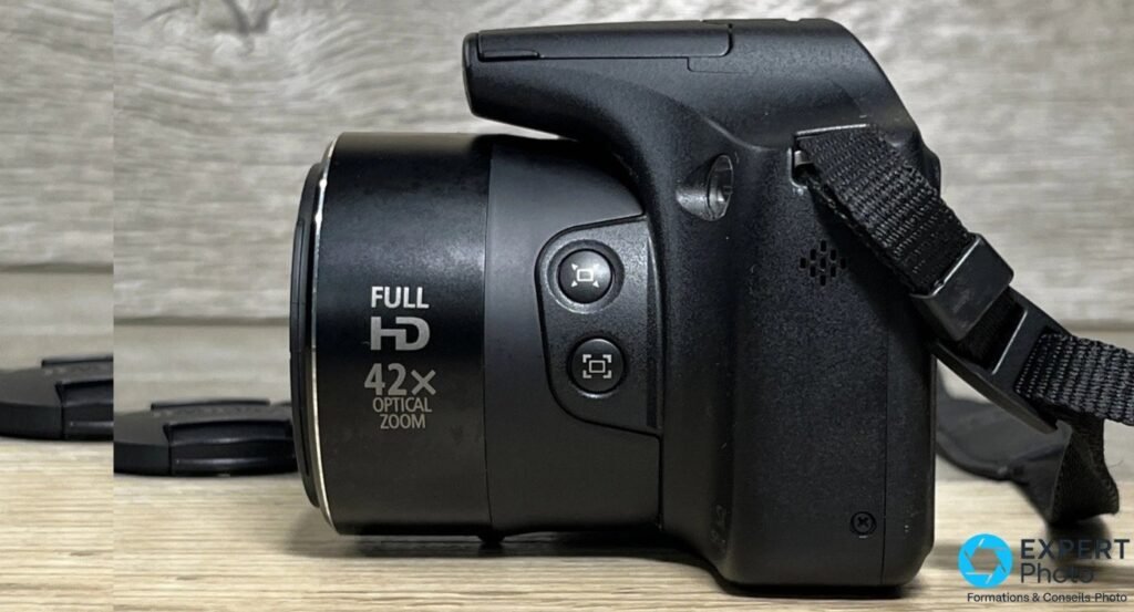 Canon PowerShot SX520 HS de profil droit, objectif rétracté, marquages Full HD et 42x Optical Zoom sur le barillet.