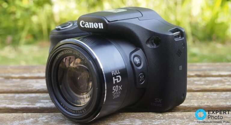 Canon PowerShot SX530 HS de face en 3/4 avant, objectif rétracté, marquages 50x optical zoom et Full HD visibles.