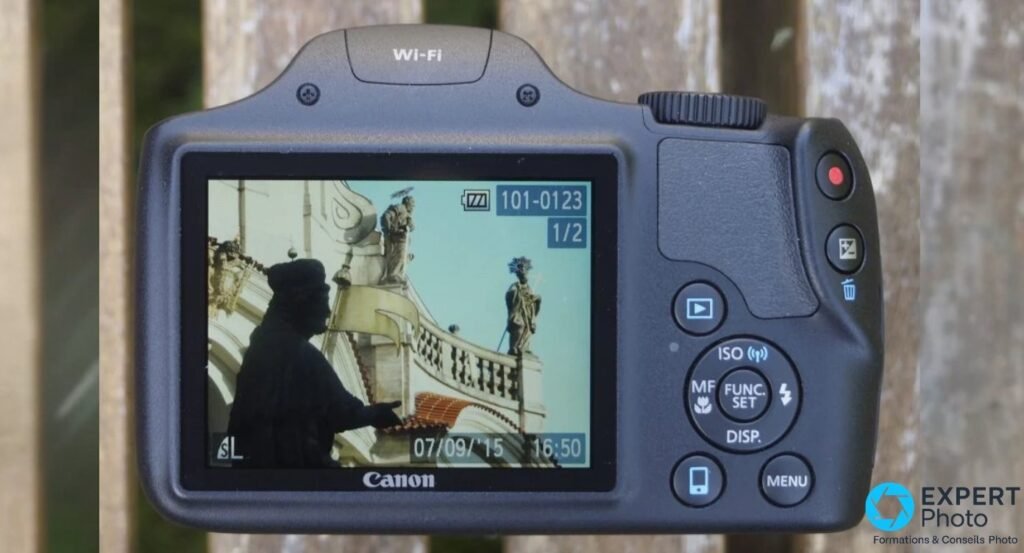 Canon PowerShot SX530 HS vu de dos, écran 3 pouces fixe affichant une photo, pad directionnel et boutons visibles. 