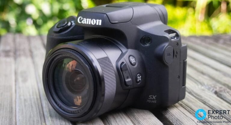 Canon PowerShot SX70 HS vu de trois-quarts avant, zoom rétracté, posé sur des planches de bois extérieures.