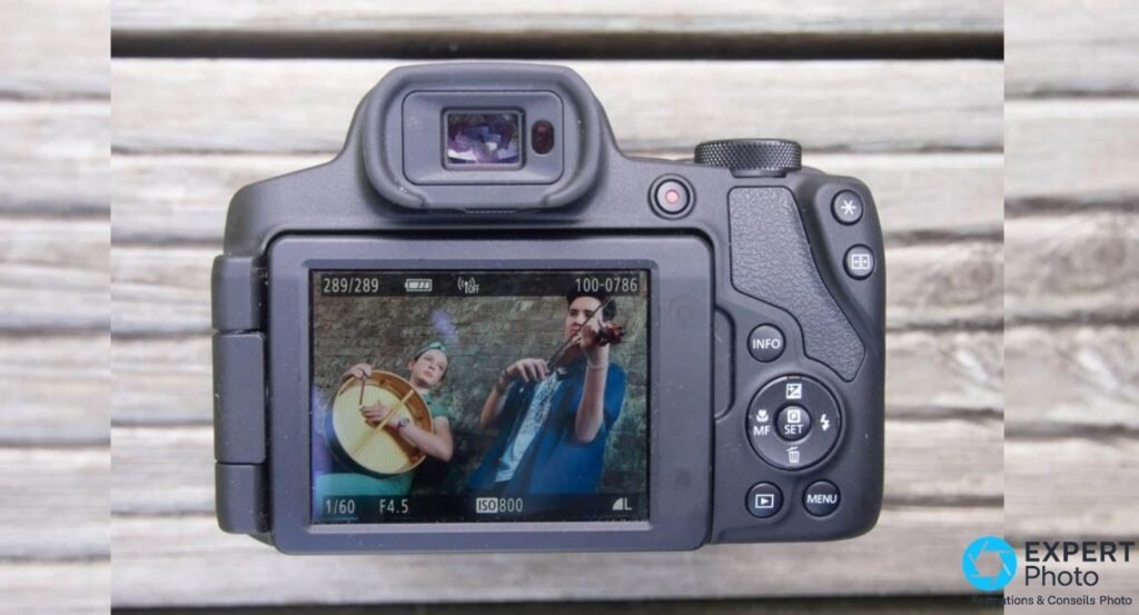 Vue arrière du Canon PowerShot SX70 HS, écran LCD orientable allumé en mode lecture, photo de musiciens.
