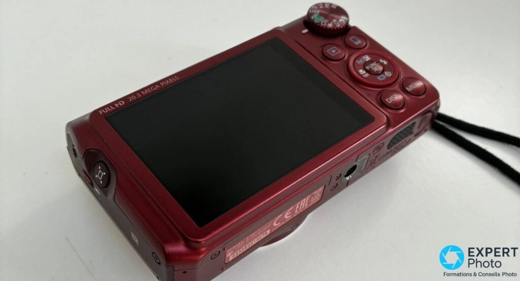 Canon PowerShot SX710 HS rouge vu de l'arrière en 3/4, écran LCD éteint, molette de modes et boutons FUNC SET, MENU, DISP.