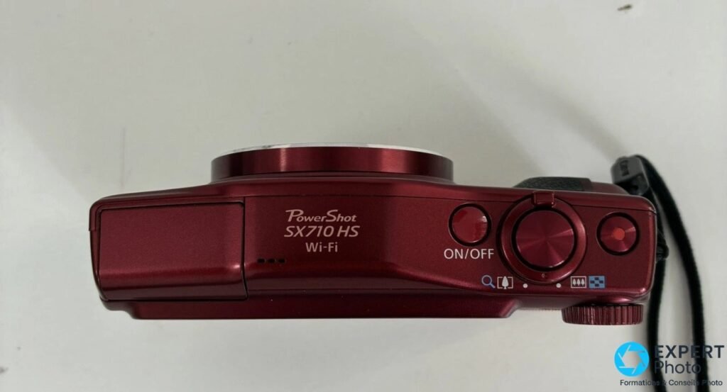 Canon PowerShot SX710 HS rouge vu de dessus, gravure PowerShot SX710 HS Wi-Fi, bouton ON/OFF et déclencheur visibles.