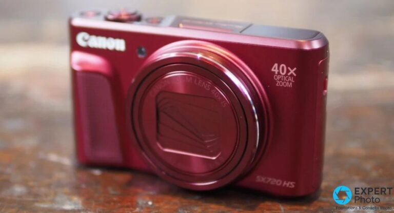 Canon PowerShot SX720 HS coloris rouge vu de trois-quarts avant posé sur une surface en bois usée