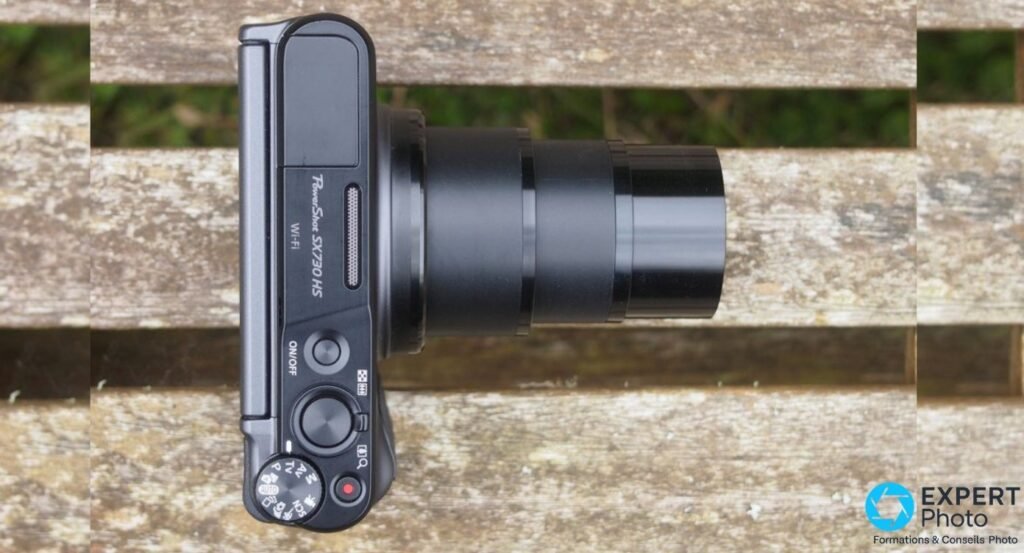 Canon PowerShot SX730 HS vu de dessus, objectif zoom 40x complètement étendu, marquage PowerShot SX730 HS Wi-Fi visible. 