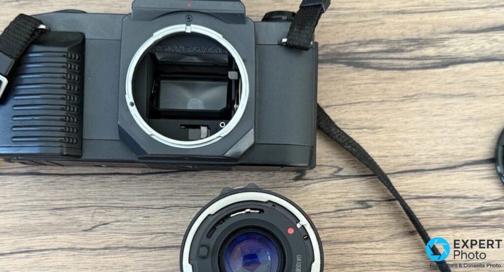 Canon T50 sans objectif, monture Canon FD ouverte, miroir et verre de visée visibles, objectif détaché 