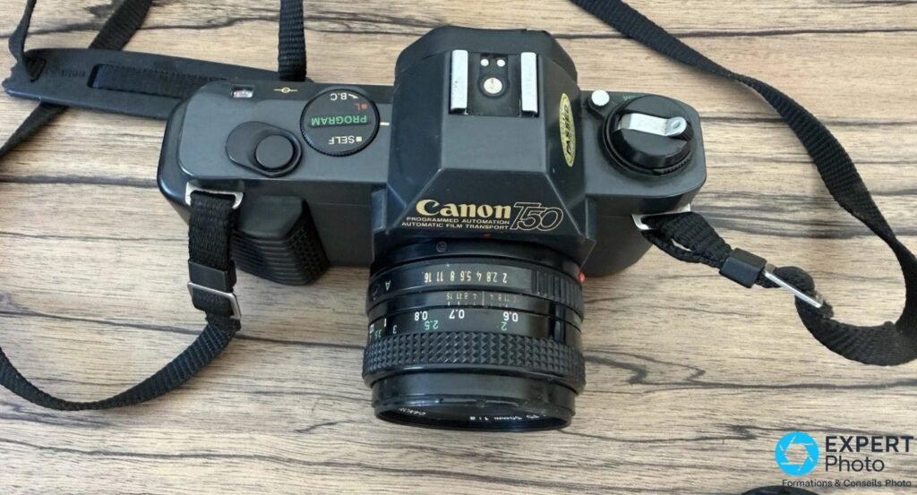 Canon T50 vu de dessus avec molette de mode SELF PROGRAM L B.C visible, griffe flash et déclencheur