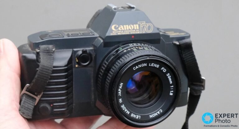 Canon T70 tenu en main avec son objectif Canon FD 50 mm f/1,8 et la sérigraphie « Multiple Program AE