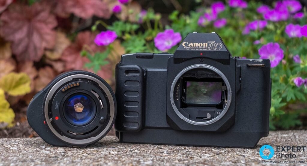  Canon T80 boîtier sans objectif, monture FD ouverte avec contacts AC visibles, optique Canon AC déposée à côté. 