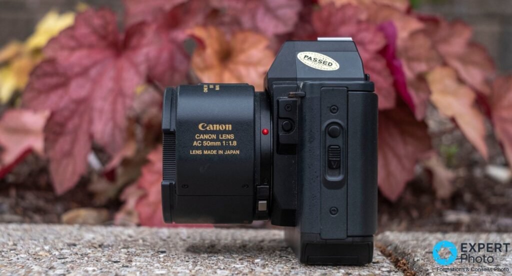 Canon T80 vu de profil équipé de l'objectif Canon AC 50 mm f/1.8, marquage doré lisible sur le barillet. 