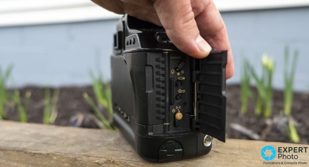 Canon T90 profil gauche, trappe latérale ouverte sur les contrôles internes : sélecteur viseur FINDER et bouton S-C 