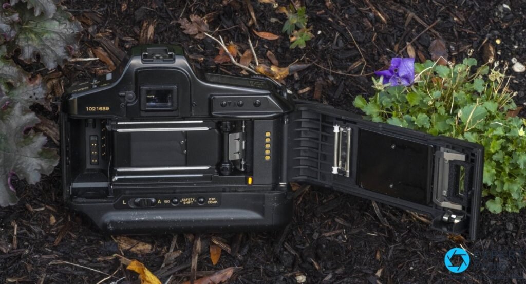Canon T90 dos ouvert : chambre du film, rideaux d'obturateur, axe d'entraînement et contacts dorés du codage DX