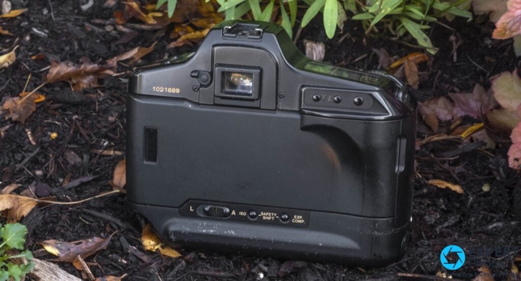 Canon T90 vu de dos en trois-quarts arrière, oeillère du viseur, boutons arrière et numéro de série gravé sur le flanc 