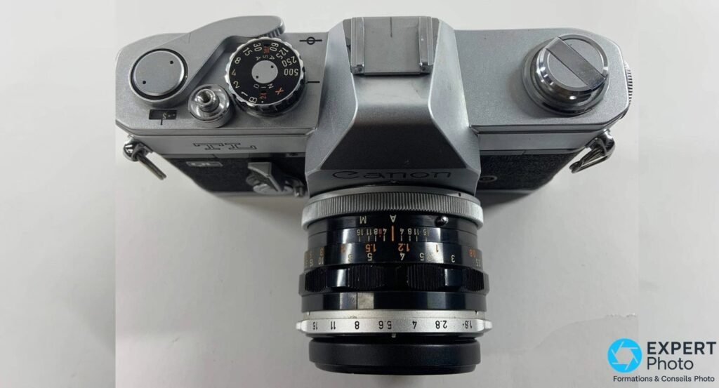 Canon TL 1968 vu de dessus, cadran des vitesses 1/500 à 1 s, marquage TL gravé, prisme Canon et objectif FL.