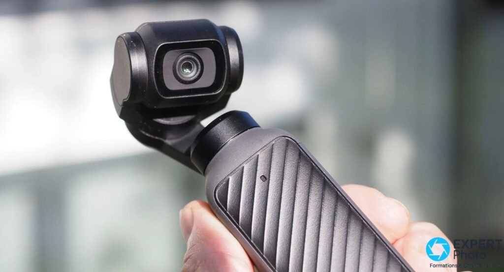 Caméra stabilisée DJI Osmo Pocket 4 tenue en main, gros plan face avant sur la nacelle et l'objectif circulaire