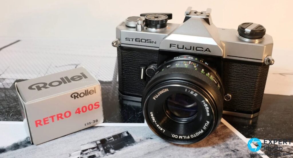 Fujica ST605N de face avec objectif Fujinon 55mm f/2.2 et boite de film Rollei Retro 400S a gauche