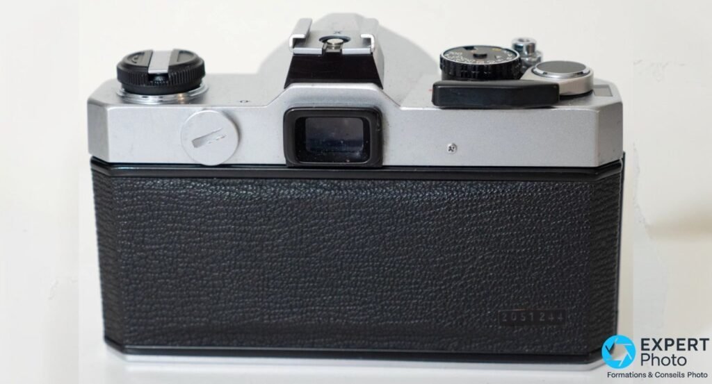 Fujica ST605 II vu de dos, dos fermé, viseur central et molette de vitesses partielle visible à droite.