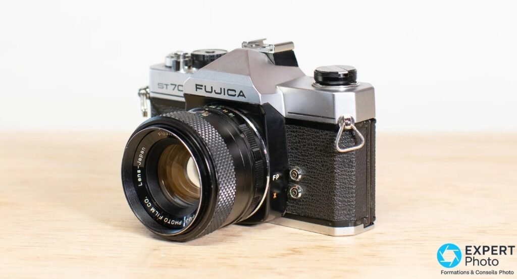 Fujica ST705 de trois quarts avant gauche, prises de synchro flash FP et X visibles.