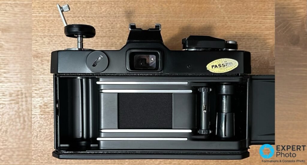 Dos ouvert du Fujica ST705W : logement film 35mm, rails, presseur, axe récepteur et manivelle de rembobinage 