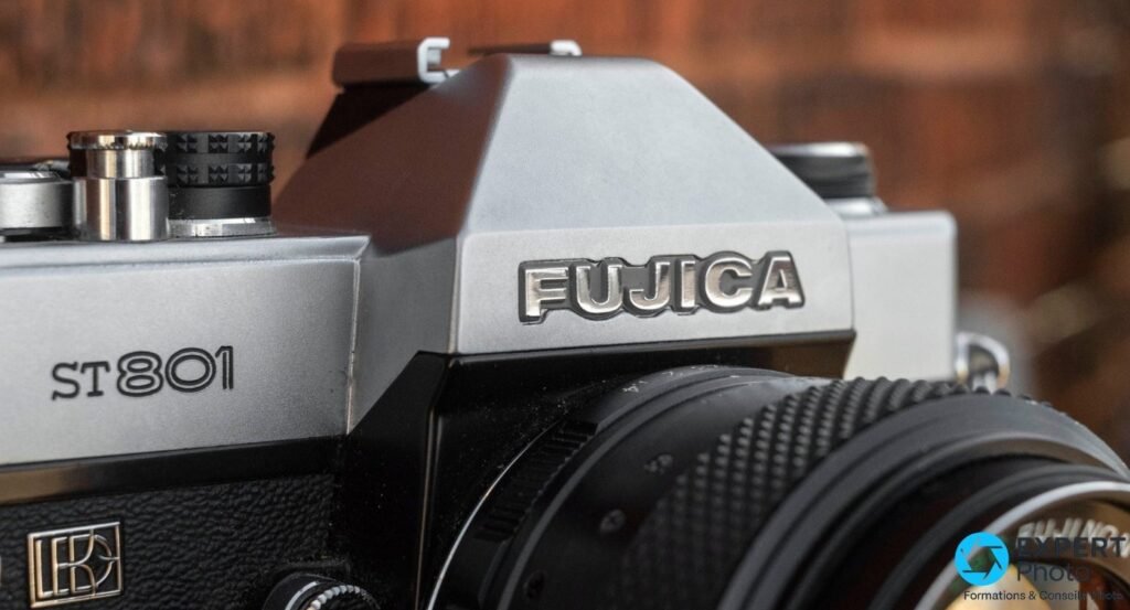 Gros plan du prisme d'un Fujica ST801 : logo Fujica gravé, mention ST801 et badge LED