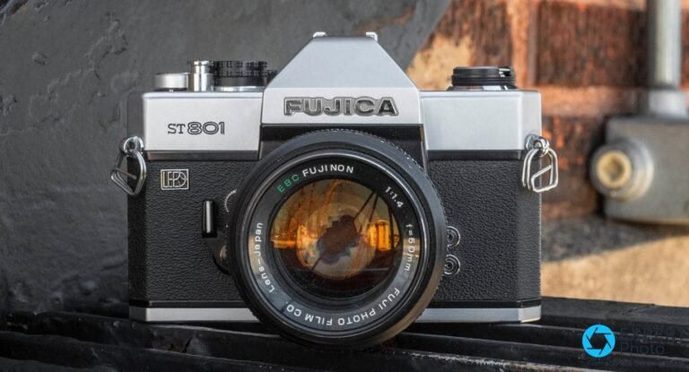 Fujica ST801 argent de face avec objectif EBC Fujinon 1:1.4 f=50mm et attaches de courroie sur fond sombre