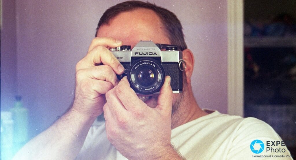 Photographe tenant le Fujica ST901 face à lui, objectif Fujinon visible, prise de vue en situation réelle 