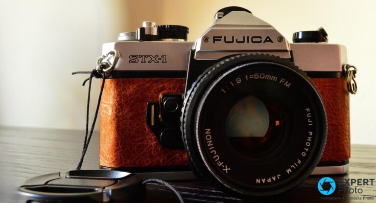 Reflex argentique Fujica STX-1 gainé de cuir brun, vu de trois-quarts avant, objectif X-Fujinon 50 mm, bouchon posé devant