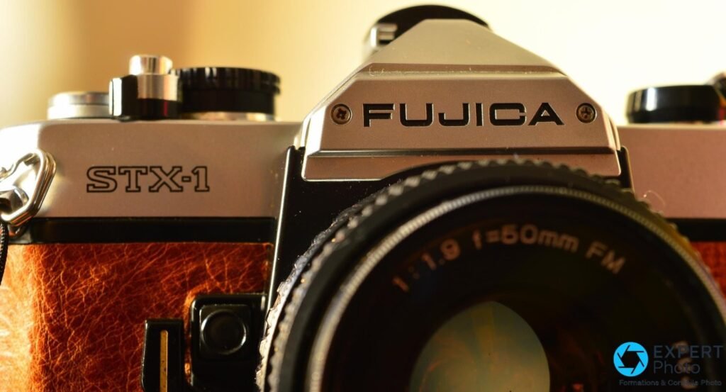  Détail du prisme Fujica STX-1 : logo FUJICA gravé, mention STX-1 et objectif 50 mm f/1.9, gainage cuir brun