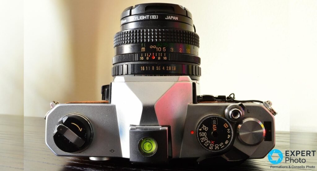  Dessus du Fujica STX-1 : molette de vitesses, échelle ASA, bague de diaphragme, niveau à bulle, objectif vers le haut