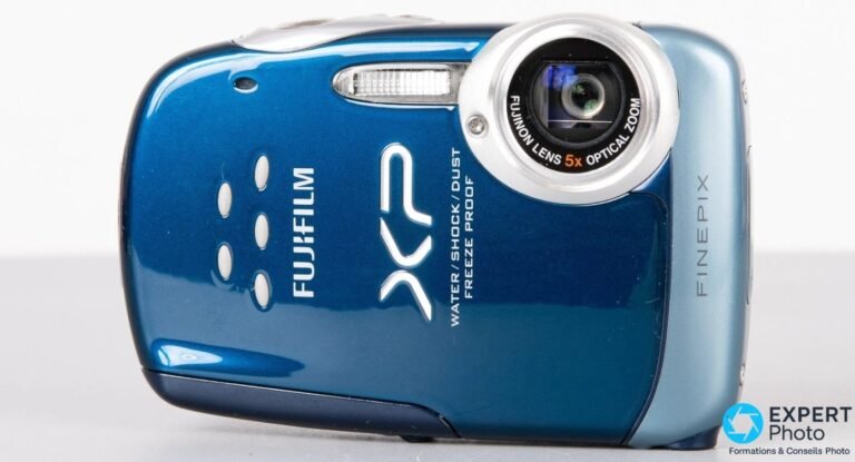 Fujifilm FinePix XP10 : faut-il encore l’acheter d’occasion en 2026 ? Fujifilm FinePix XP10 bleu de face avec objectif Fujinon 5x et logos XP, FINEPIX, water shock dust freeze proof