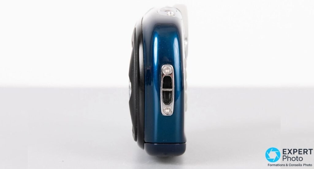 Fujifilm FinePix XP10 de profil bleu foncé avec deux ouvertures rectangulaires verticales encadrées d'argenté