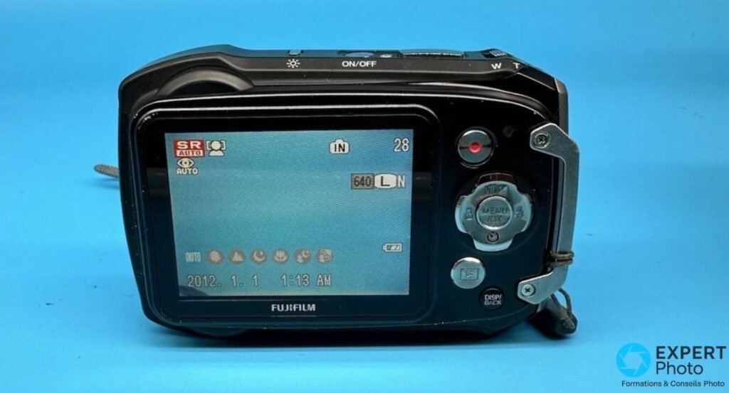 Écran arrière du Fujifilm FinePix XP100 allumé, mode SR AUTO, date 2012 et molette MENU/OK visibles.