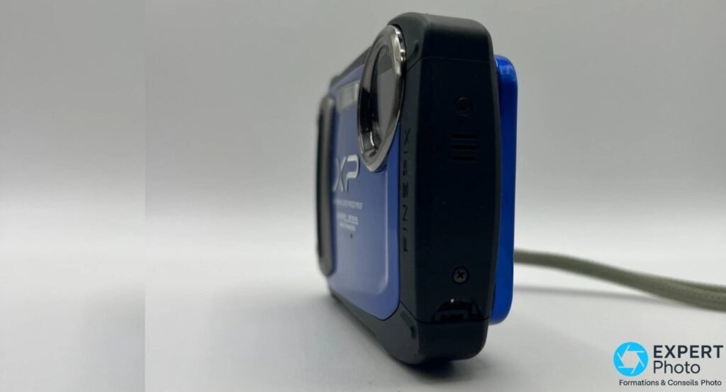 Profil du Fujifilm FinePix XP170 bleu, côté objectif rétracté et grille du haut-parleur visibles.