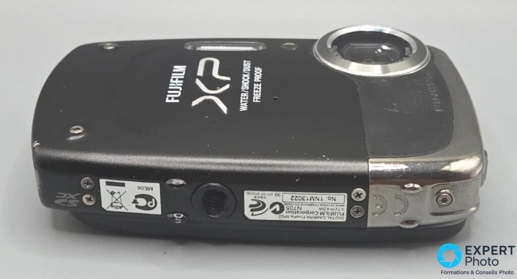 Fujifilm FinePix XP20 vu de dessous : étiquette serial DIGITAL CAMERA FinePix XP20, filetage trépied et logo FUJIFILM XP.