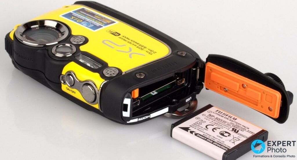 Fujifilm FinePix XP200 trappe latérale ouverte sur la batterie Fujifilm NP-50, ports USB et HDMI visibles.