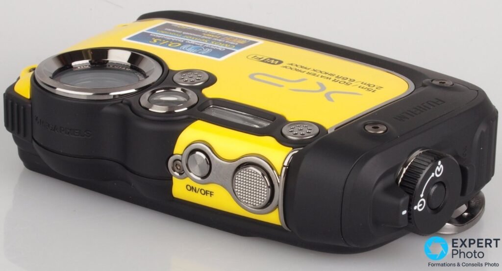 Fujifilm FinePix XP200 vu de dessus, bouton ON/OFF, déclencheur crénelé et molette de mode rotative visibles.