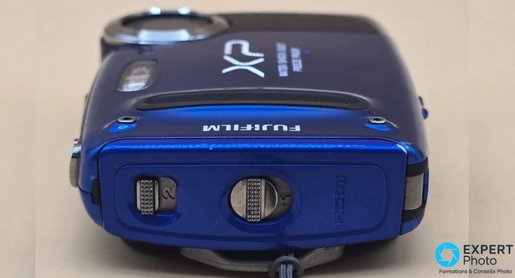 Dessous du Fujifilm FinePix XP50, pas de vis trépied, trappe HDMI fermée et logo Fujifilm gravé.