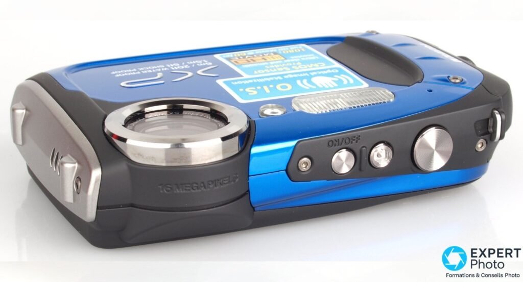 Fujifilm FinePix XP60 vu de trois-quarts, marquage 16 megapixels lisible sur le barillet et grille speaker latérale.