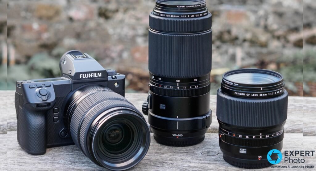 Fujifilm GFX100 II et deux objectifs GF, zoom 100-200 mm et 55 mm, posés sur un banc en bois